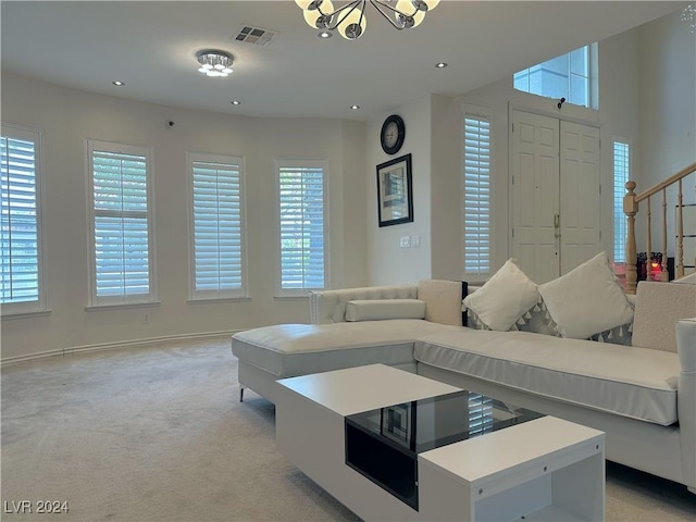 living area with light carpet, a healthy amount of sunlight, stairway, and visible vents