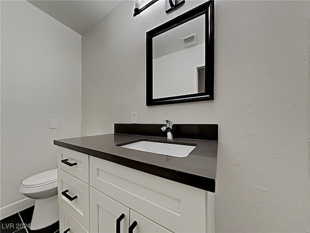 bathroom featuring toilet, vanity, and tile patterned flooring