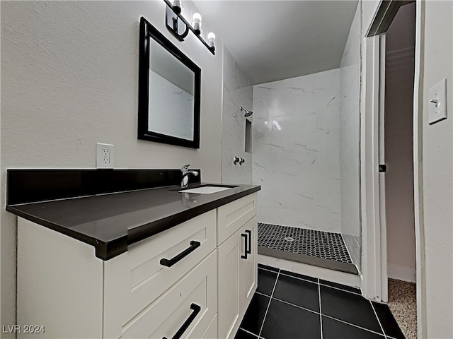 bathroom featuring a tile shower, tile patterned floors, and vanity