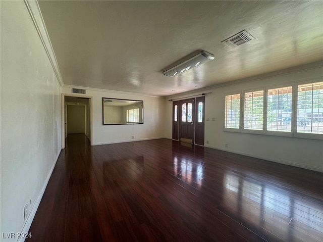 empty room featuring dark hardwood / wood-style floors and crown molding