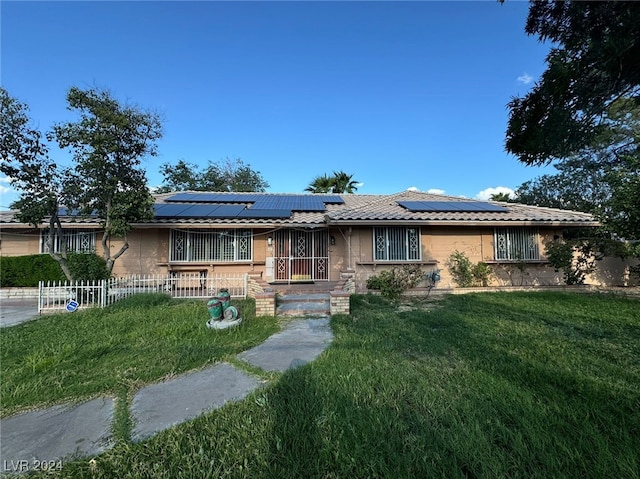 ranch-style house with solar panels and a front lawn