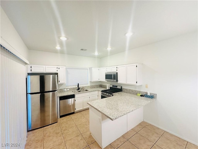 kitchen featuring kitchen peninsula, stainless steel appliances, light tile patterned flooring, white cabinets, and sink