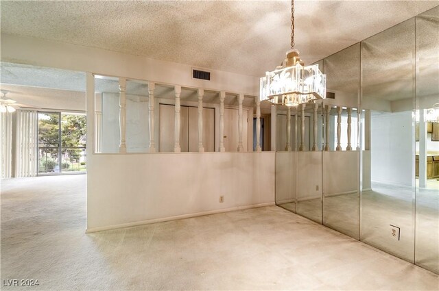 empty room featuring ceiling fan with notable chandelier, a textured ceiling, and carpet floors