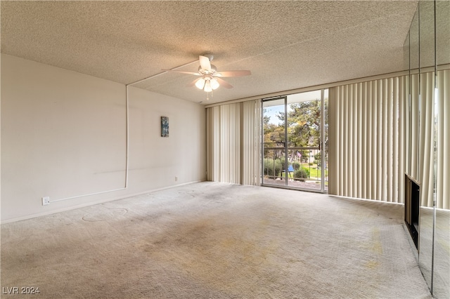 carpeted empty room featuring ceiling fan and a textured ceiling