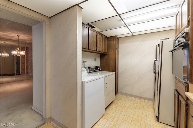 laundry room featuring a chandelier, independent washer and dryer, and cabinets