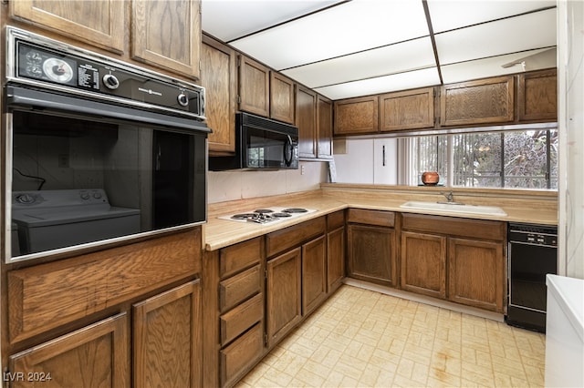 kitchen featuring light tile patterned floors, sink, and black appliances