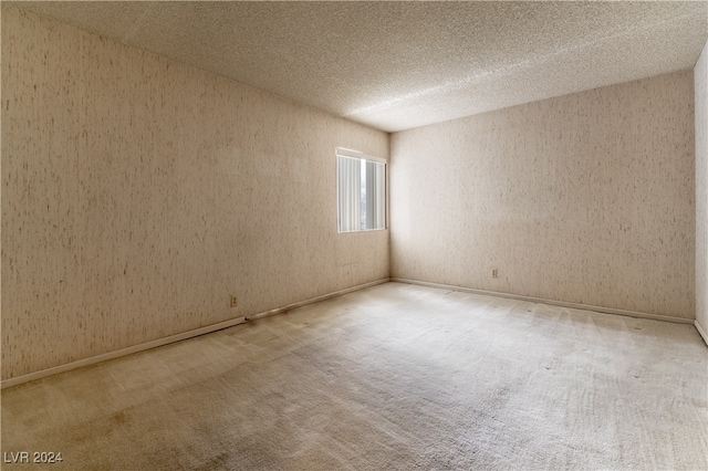 carpeted spare room with a textured ceiling