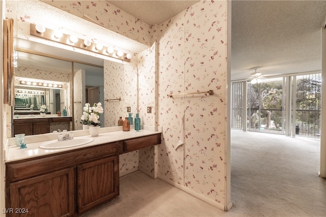 bathroom with ceiling fan, a textured ceiling, and vanity