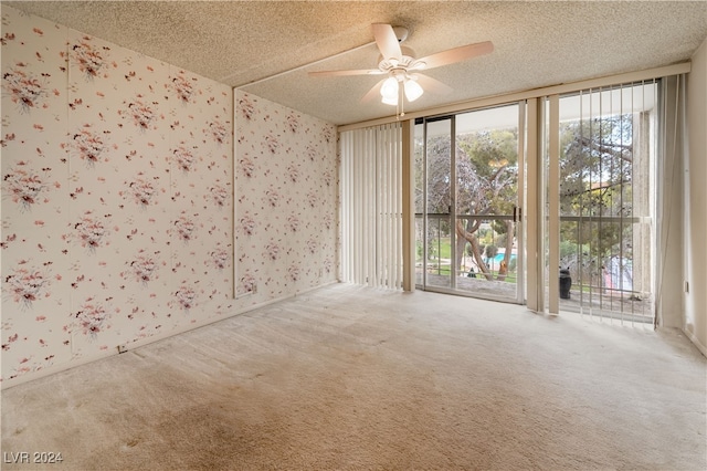 unfurnished room featuring a textured ceiling, light carpet, and a healthy amount of sunlight