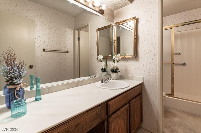 bathroom with a shower with shower door, a textured ceiling, vanity, and toilet