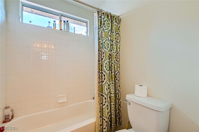 bathroom with shower / bathtub combination with curtain and toilet