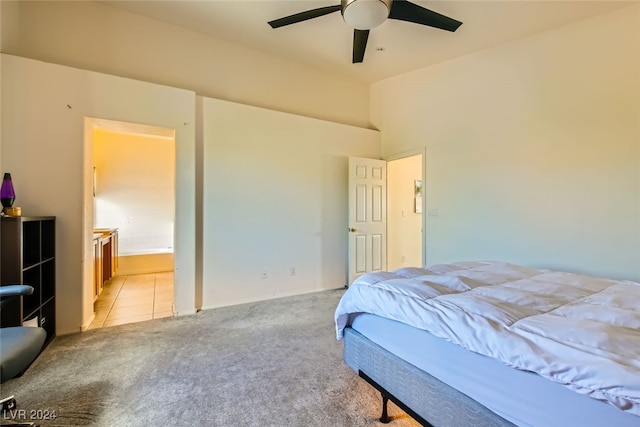 bedroom with connected bathroom, ceiling fan, light colored carpet, and a high ceiling