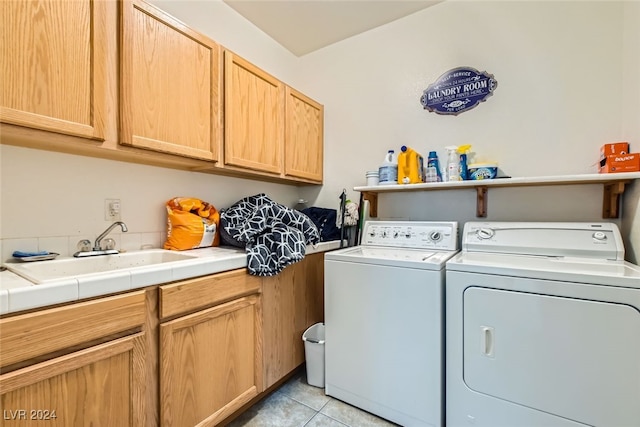 clothes washing area featuring cabinets, sink, independent washer and dryer, and light tile patterned flooring