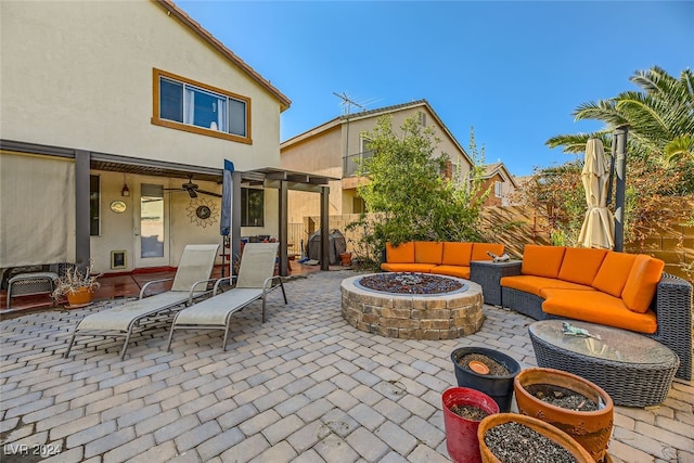 view of patio with a pergola, ceiling fan, and an outdoor living space with a fire pit