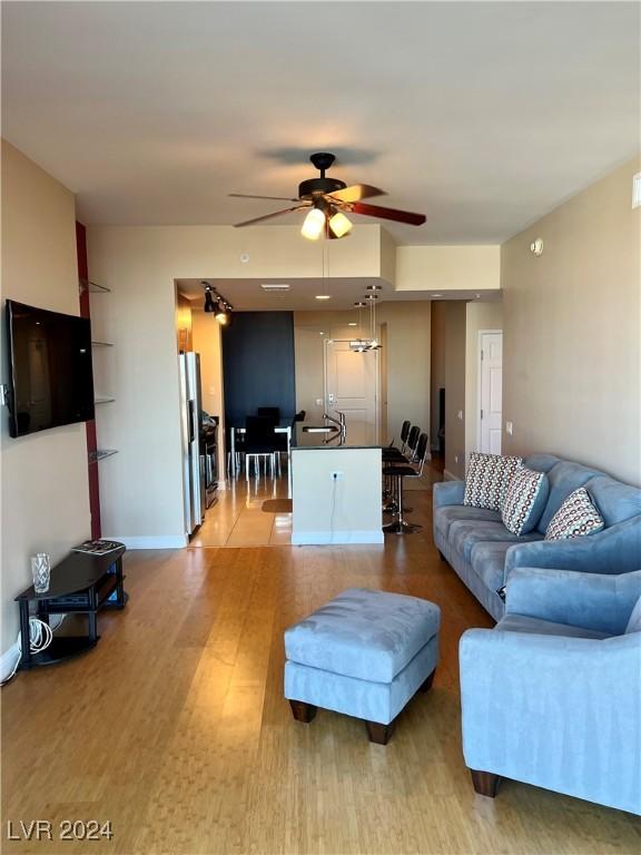 living room with light hardwood / wood-style flooring, sink, and ceiling fan