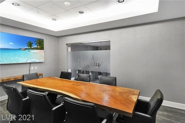 office space with baseboards and a raised ceiling