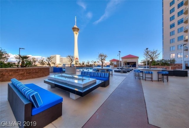 view of patio / terrace with an outdoor living space with a fire pit and outdoor dry bar