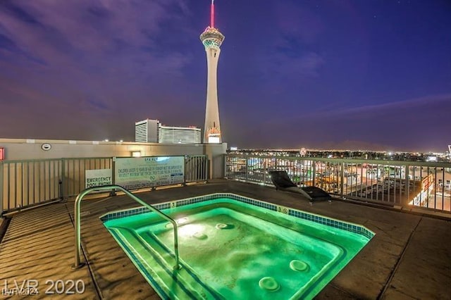 view of swimming pool featuring a hot tub