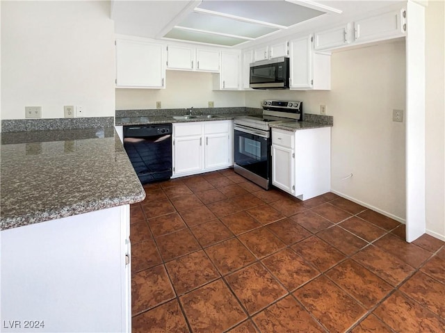 kitchen featuring sink, dark tile patterned floors, white cabinetry, dark stone countertops, and stainless steel appliances