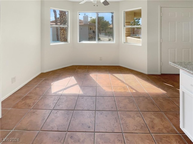 empty room featuring tile patterned floors and ceiling fan