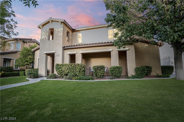 mediterranean / spanish home with a tiled roof, a front yard, and stucco siding