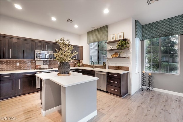 kitchen featuring visible vents, a kitchen island, appliances with stainless steel finishes, and light countertops