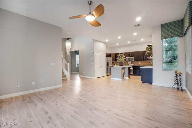 unfurnished living room with stairs, ceiling fan, light wood-type flooring, and visible vents