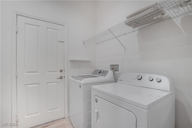 laundry room with light wood-style floors, washing machine and dryer, and laundry area