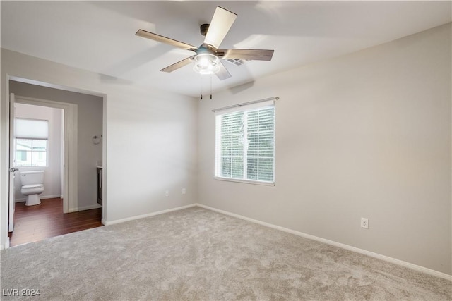 unfurnished bedroom featuring carpet, connected bathroom, baseboards, and ceiling fan