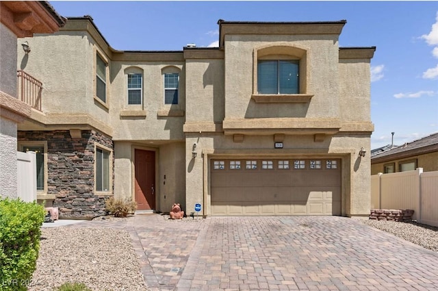 multi unit property featuring fence, driveway, stucco siding, and a garage