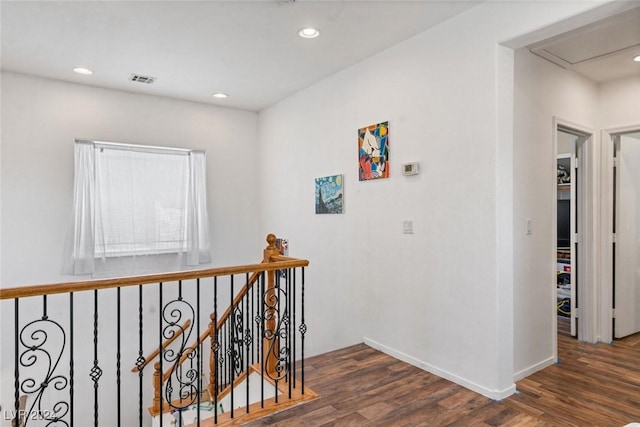 corridor with an upstairs landing, baseboards, wood finished floors, and recessed lighting