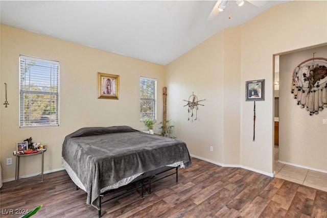 bedroom featuring hardwood / wood-style floors, lofted ceiling, and multiple windows