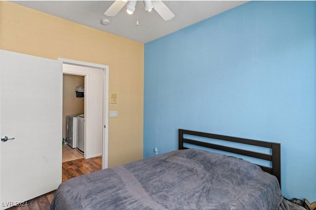 bedroom featuring washing machine and dryer, wood finished floors, and ceiling fan