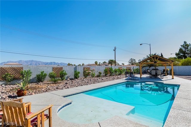 view of swimming pool featuring a mountain view, a patio area, and a gazebo