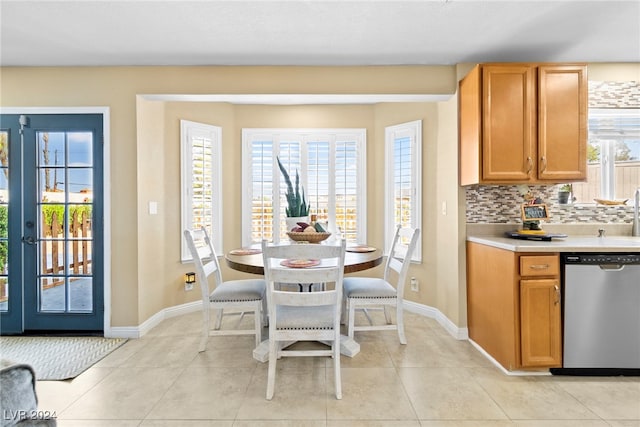 kitchen featuring decorative backsplash, french doors, light tile patterned floors, and dishwasher