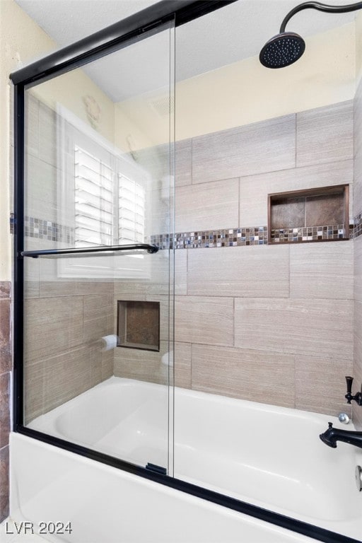 bathroom featuring combined bath / shower with glass door