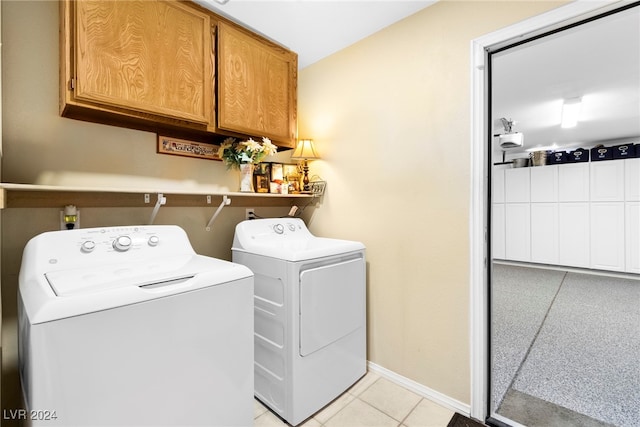 laundry area featuring cabinets, light tile patterned flooring, and separate washer and dryer