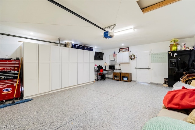 garage with black fridge with ice dispenser and a garage door opener