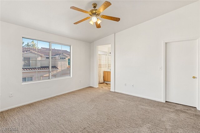 unfurnished bedroom featuring connected bathroom, lofted ceiling, ceiling fan, and light colored carpet