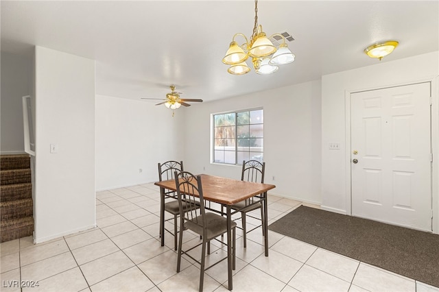 tiled dining room with ceiling fan with notable chandelier