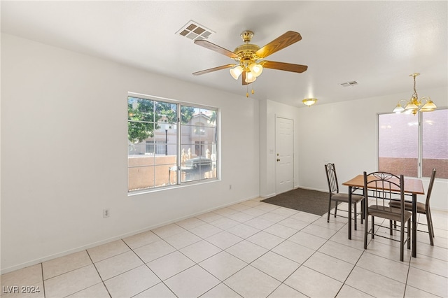 dining room featuring ceiling fan with notable chandelier and light tile patterned floors