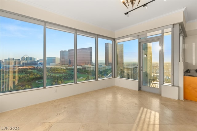 unfurnished room with light tile patterned floors and crown molding