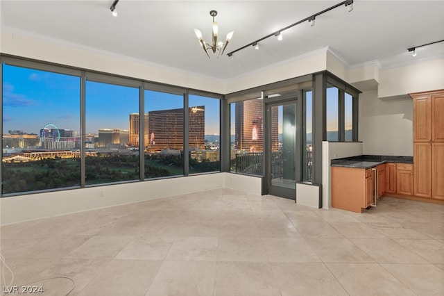 kitchen featuring pendant lighting, light tile patterned floors, track lighting, and ornamental molding