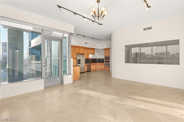 unfurnished living room featuring a wealth of natural light, track lighting, and light tile patterned floors