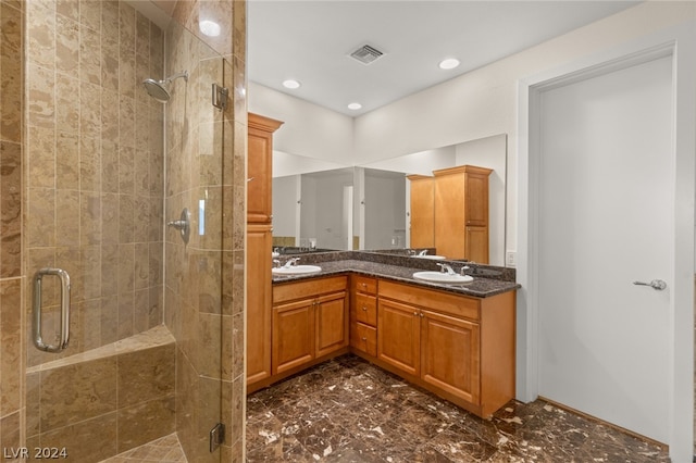 bathroom featuring a shower with shower door, tile patterned flooring, and dual vanity