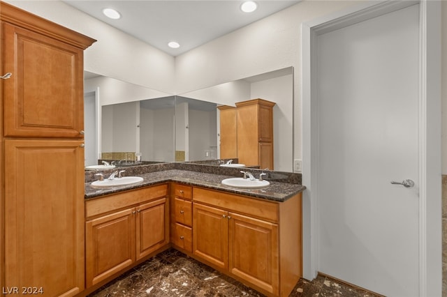 kitchen featuring dark tile patterned flooring, sink, and dark stone countertops