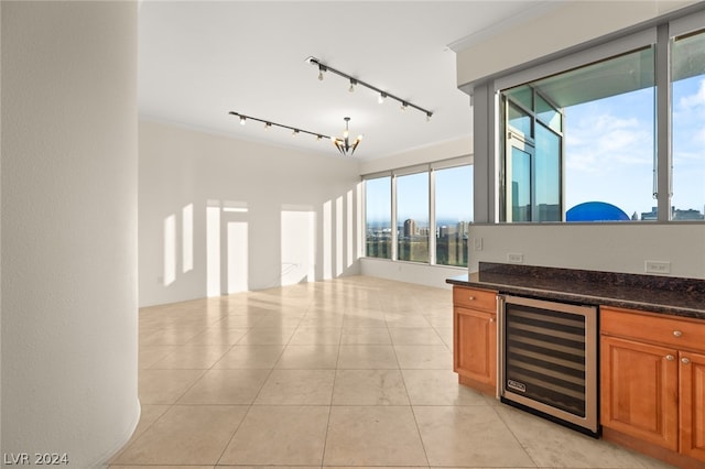 kitchen featuring light tile patterned flooring, wine cooler, an inviting chandelier, and track lighting