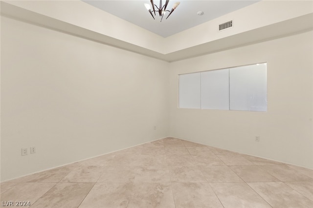 empty room featuring light tile patterned floors and an inviting chandelier