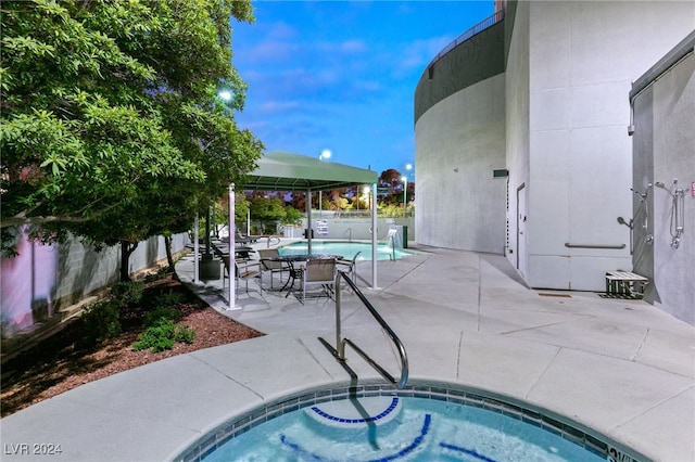 view of swimming pool featuring a hot tub and a patio