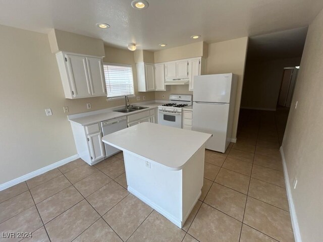 kitchen with white cabinetry, a kitchen island, light tile patterned flooring, white appliances, and sink